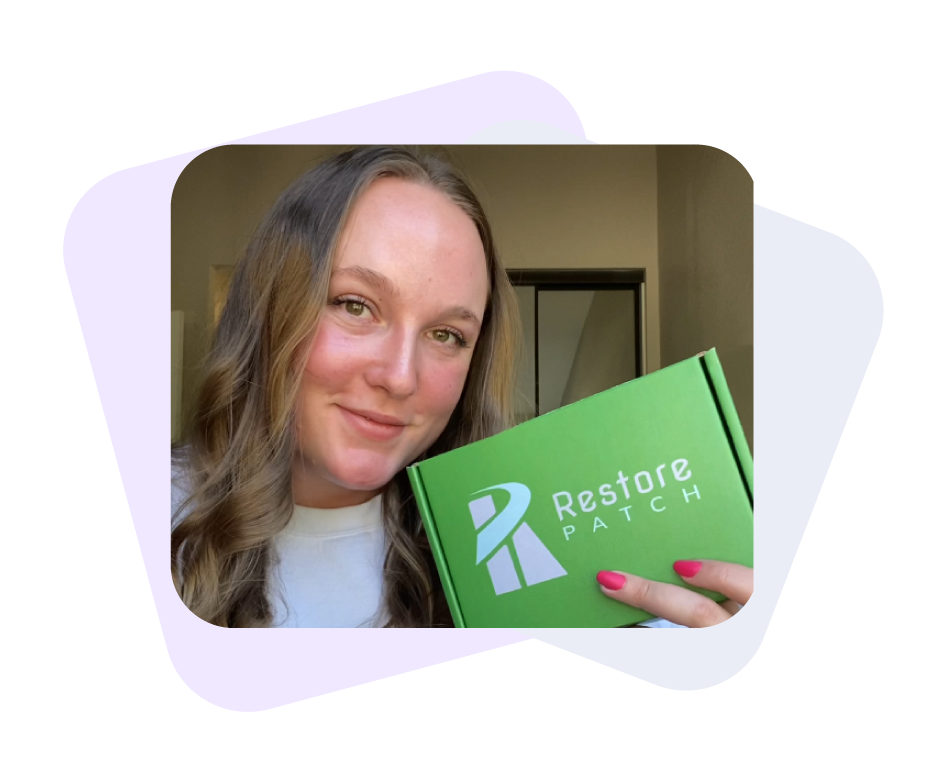 A woman is smiling while holding a green Restore Patch Anxiety Relief Patch.