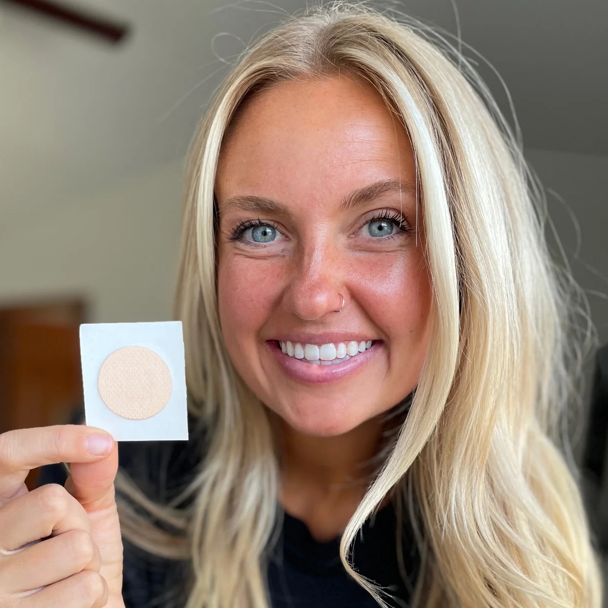 Smiling woman holding the immune patch page.
