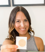Load image into Gallery viewer, A smiling woman is wearing a striped tank top while holding and showing a Restore patch.
